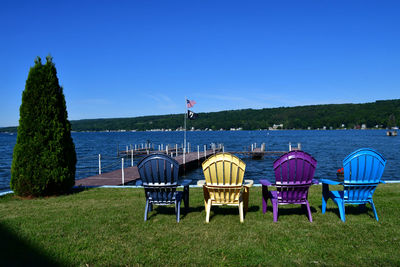 Colorful adirondack chairs next to lake keuka in the finger lakes region of new york.