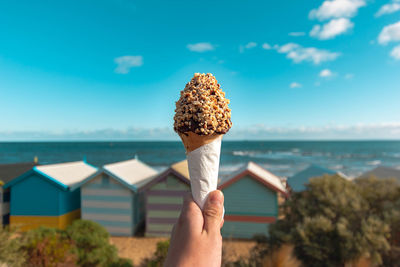 Midsection of person holding umbrella on beach