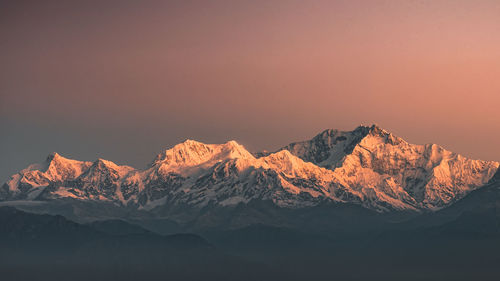 Scenic view of snowcapped mountains against sky during sunset