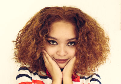 Close-up of young woman against white background