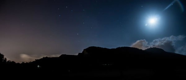 Silhouette mountain against sky at night