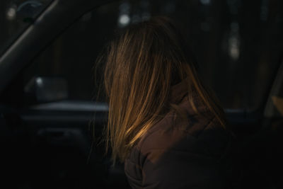 Side view of woman traveling in car at night