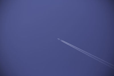 Low angle view of vapor trail against blue sky