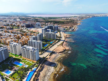 High angle view of townscape by sea against sky