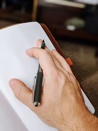 High angle view of human hand on notebook