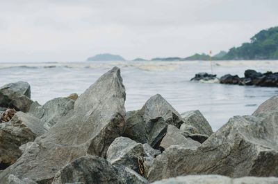 Close-up of rocks on beach against sky