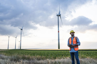 Engineer holding tablet pc at wind farm