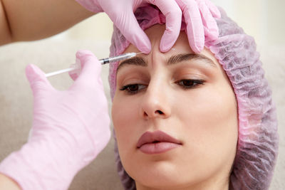 Close-up of young woman applying nail polish