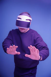 Midsection of man standing against blue background