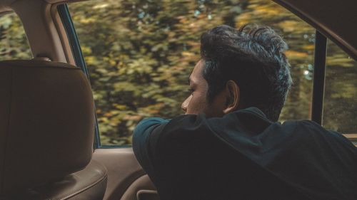 Rear view of man sitting in car