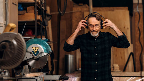 Carpenter wearing ear muffs at workshop