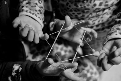 Midsection of children playing with rubber band