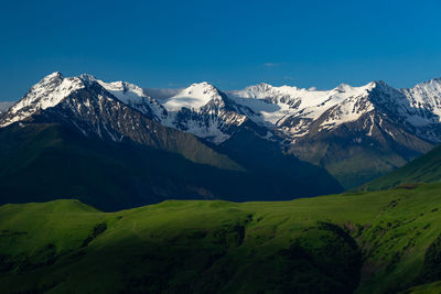 Scenic view of snowcapped mountains against blue sky