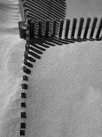 High angle view of empty chairs on sand at beach