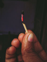 Close-up of hand holding cigarette