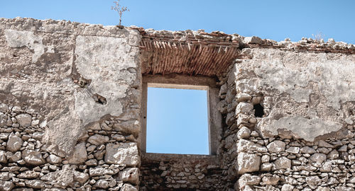 Low angle view of stone wall against clear sky