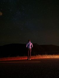 Full length of woman running on field against sky at night