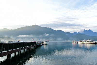 Yachts moored at harbor in lake