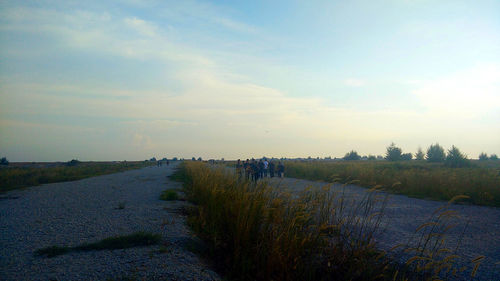 Road amidst field against sky