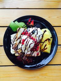 Directly above shot of dessert in plate on wooden table