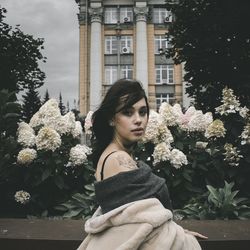 Side view of woman against red flowering plants