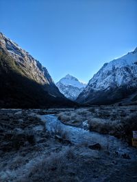 Scenic view of snowcapped mountains against clear blue sky