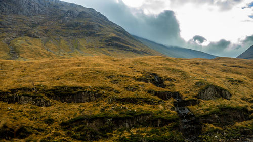 Scenic view of mountains against cloudy sky