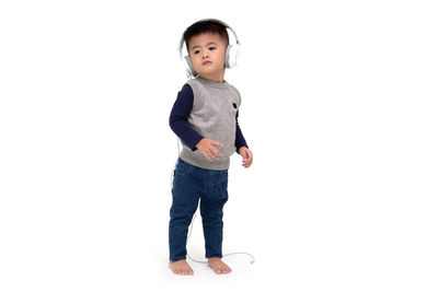 Portrait of cute boy standing against white background