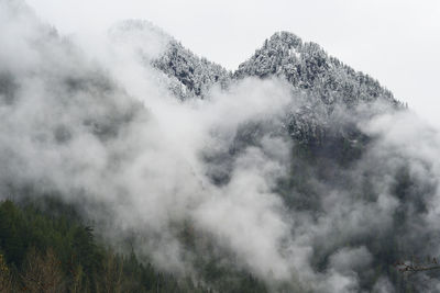 Snow covered mountain peaks with fog