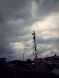 Low angle view of crane against cloudy sky