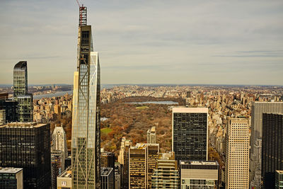 High angle view of buildings in city against cloudy sky