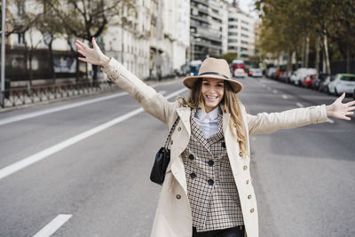 Portrait of woman standing on street in city