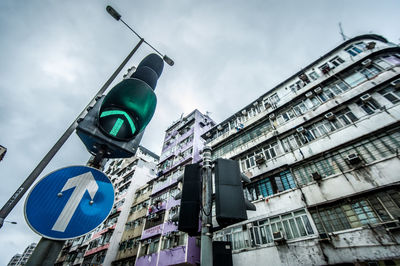 Low angle view of road sign against buildings in city