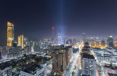 Illuminated cityscape against sky at night