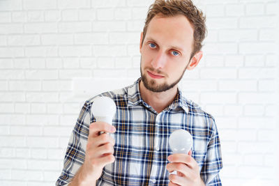 Portrait of man holding light bulbs