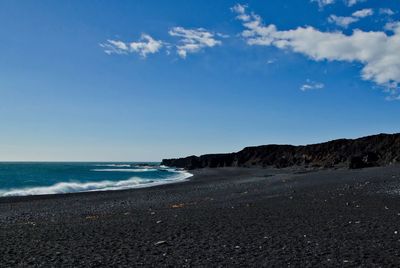 Scenic view of beach against blue sky