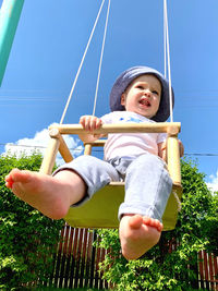 Low angle view of girl standing on playground against sky