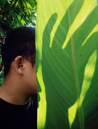 Portrait of boy on green plant