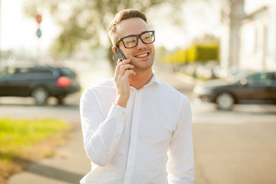 Midsection of man using mobile phone in city