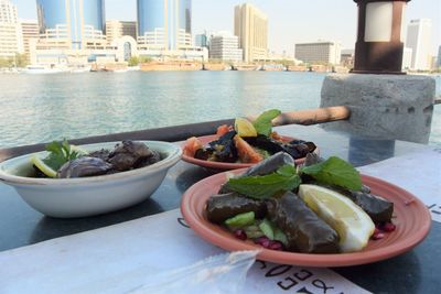 Close-up of vegetables in bowl on table against buildings