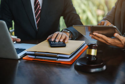 Midsection of lawyer working at table