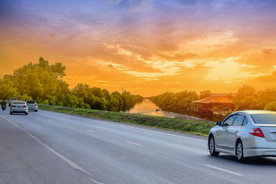 Car on road against sky during sunset