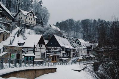 Snow covered houses and buildings against sky