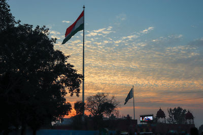 Silhouette flag against sky during sunset