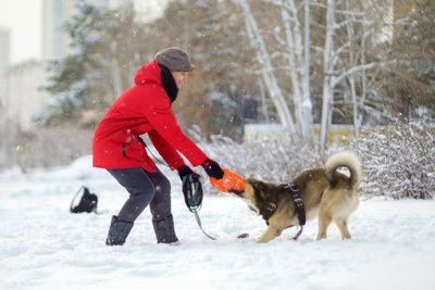 Side view of dog walking on snow covered field