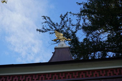 Low angle view of statue on building against sky