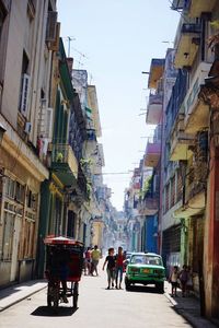 Rear view of people walking on road in city