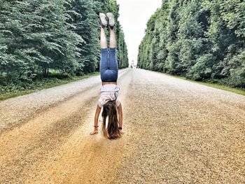 Woman doing handstand on footpath