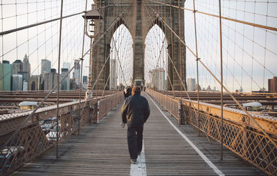 Rear view of woman on suspension bridge