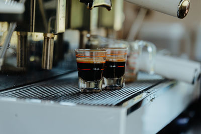 Espresso shot coffee flows from the coffee machine.